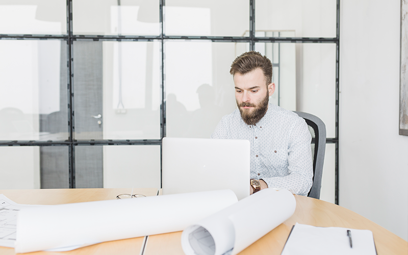 hombre-de-negocios-trabajando-con-portatil-en-oficina