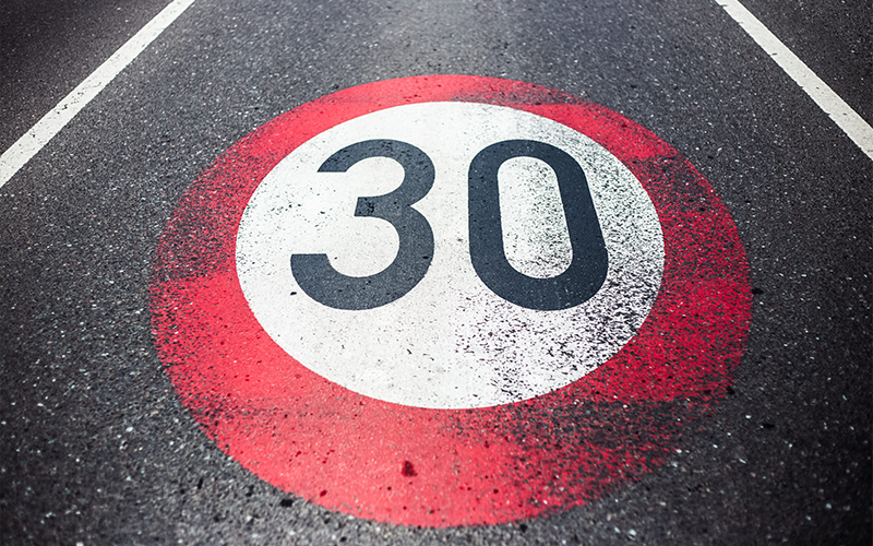 senal-de-limite-de-velocidad-de-30-km-h-pintada-en-carretera-asfaltada-scaled